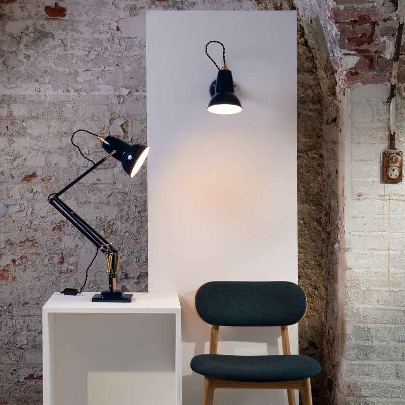 Dark blue Anglepoise desk lamp on a white unit with a matching wall-mounted lamp above.
