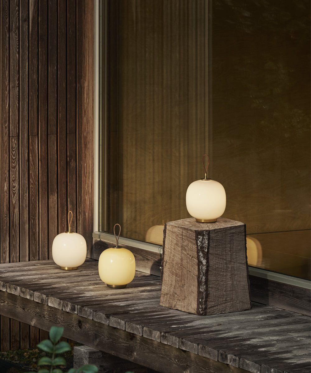 A balcony setting featuring three of the Louis Poulsen VL45 portable lamps