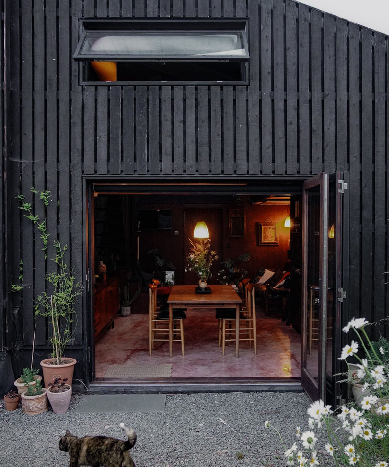 Exterior image of the cabin with the bifold doors open looking into the dining room