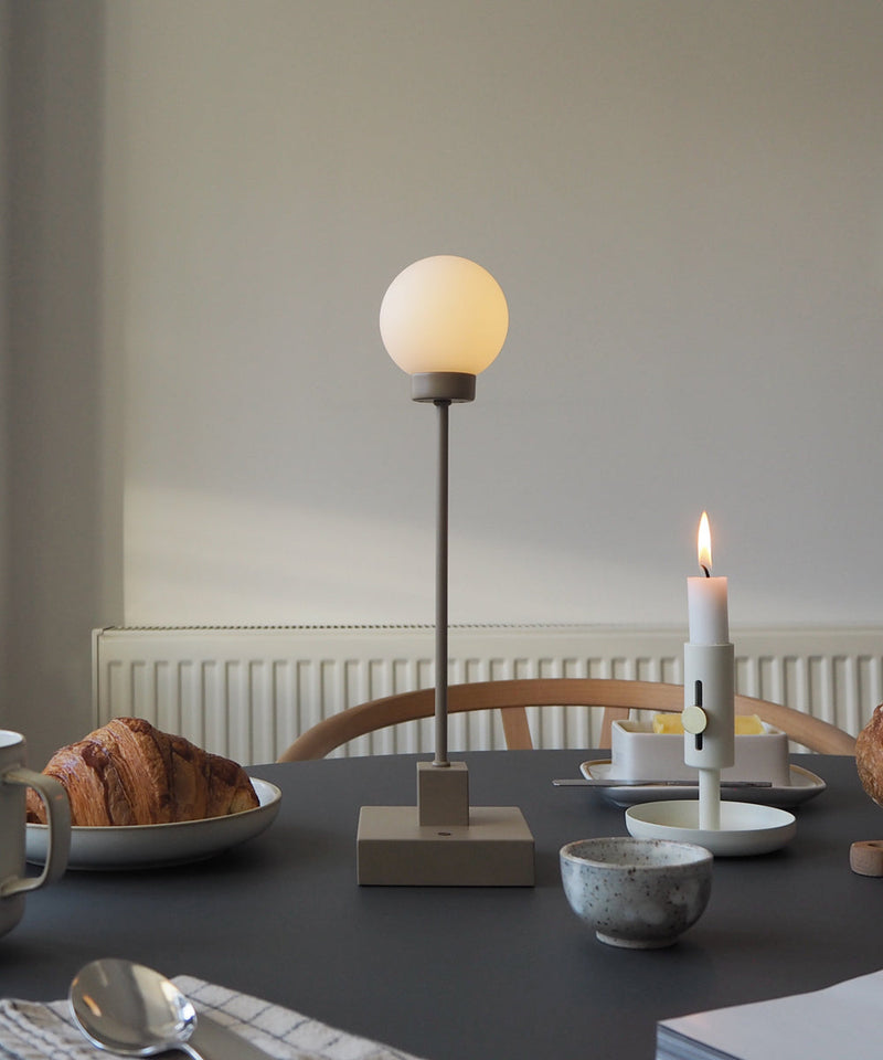 The portable Snowball lamp on a dining table with breakfast items surrounding it