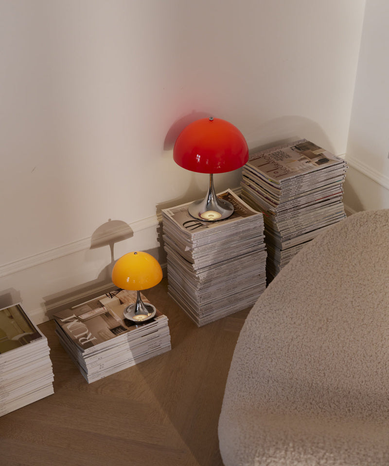 The Louis Poulsen 160 and 250 in two different colours on a stack of magazines