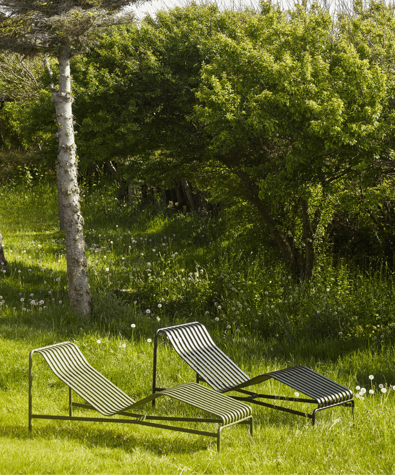 Two HAY Palissade Chaise Longue set in a sunny countryside location